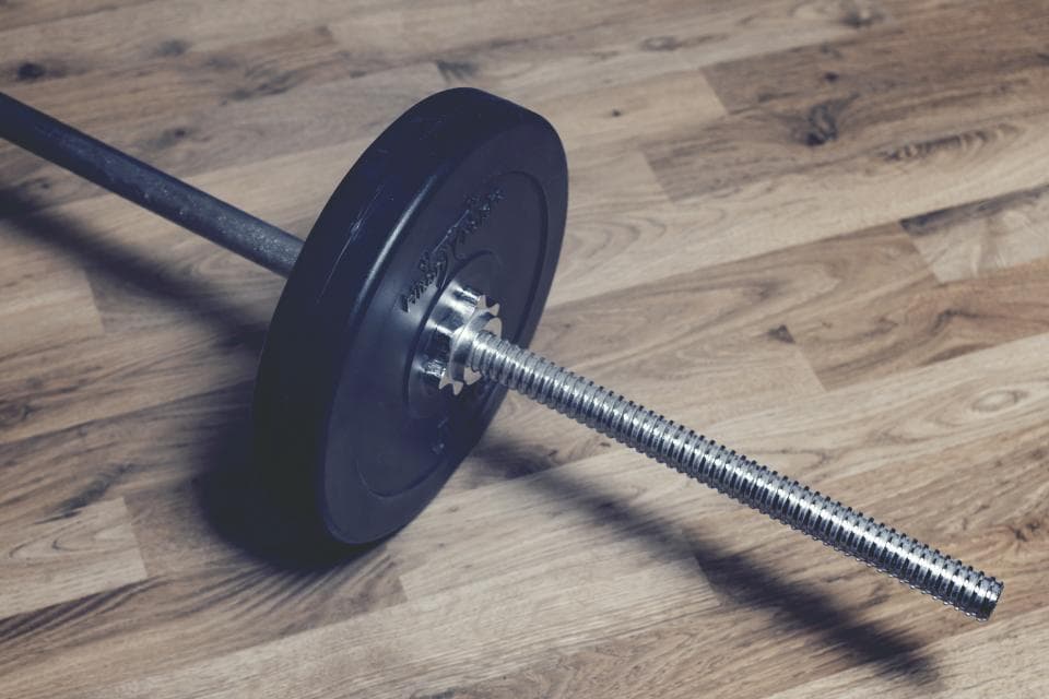 A loaded barbell on a wooden platform